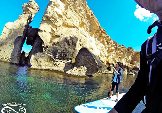 stand up paddle through Ibiza waters and rock formation