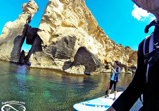 stand up paddle through Ibiza waters and rock formation