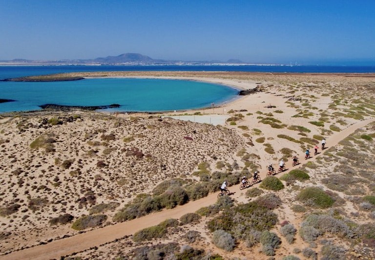 Cycling in Lobos island with white sand beach and turquoise waters.jpg