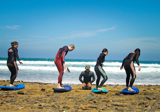 surfing course students with instructor in lanzarote coast